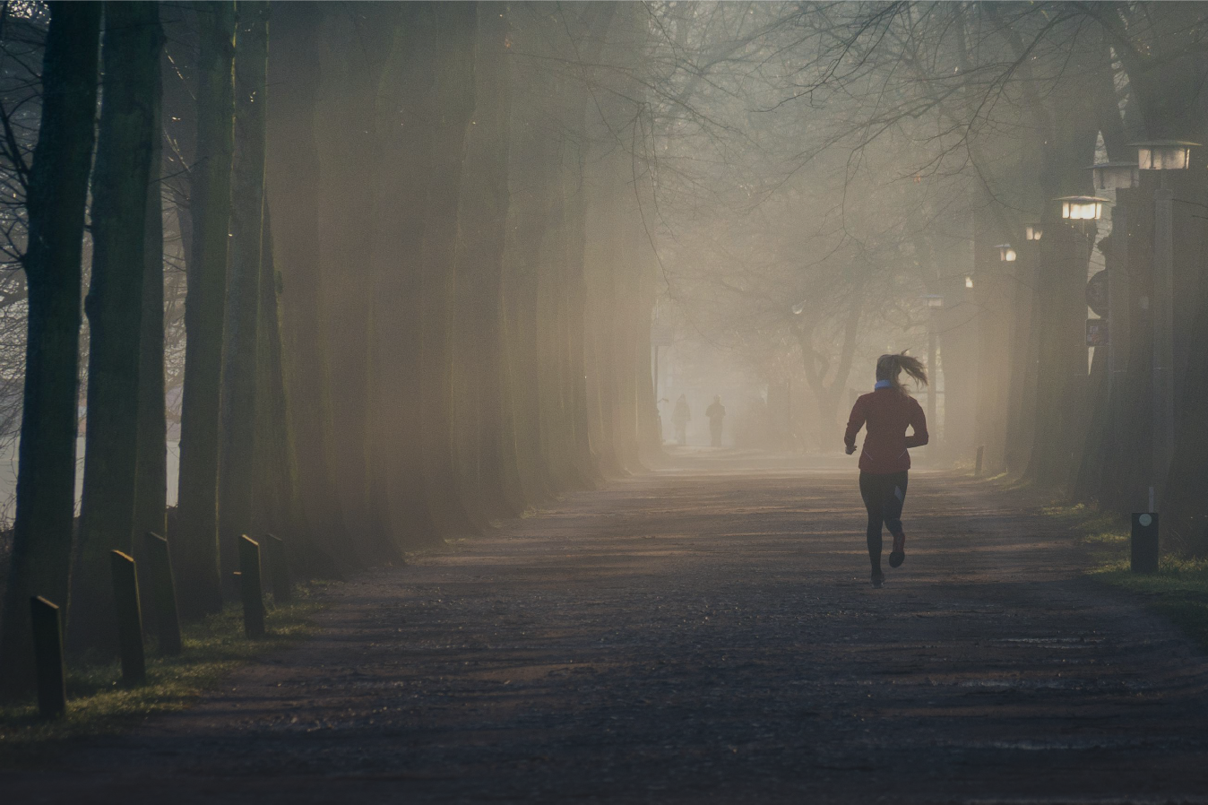 woman running in a foggy park during winter